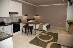 a kitchen and a living room with a bed at Grey Corner Guesthouse in Postmasburg