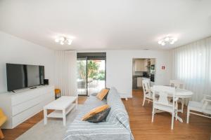 a living room with a couch and a tv and a table at Casa de Salgueiros in Canidelo
