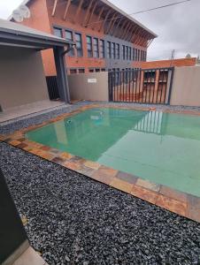 a swimming pool in front of a building at Grey Corner Guesthouse in Postmasburg