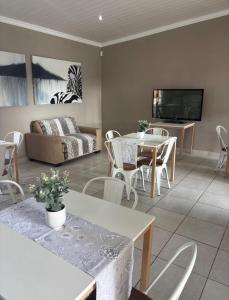 a living room with tables and chairs and a couch at Grey Corner Guesthouse in Postmasburg