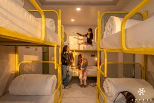 a group of people standing in a room with bunk beds at Zostel Jaipur, MI Road in Jaipur