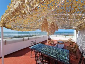 a patio with tables and chairs and a view of the beach at Plage El Haouzia in El Jadida