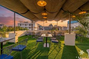 a patio with tables and chairs on the roof of a building at Zostel Jaipur, MI Road in Jaipur
