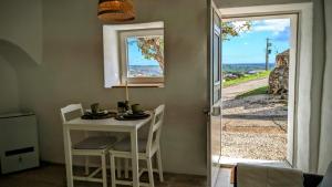 a small table and chairs in a room with a window at Casa Nossa in Azinhal