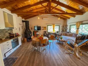 a kitchen and living room with a table and a couch at Elaia Rest House Retreat in nature in Fréngaina