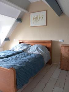 a bedroom with a bed with a blue comforter at B&B De koekoeksklok in IJsselmuiden
