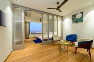 a room with a bed and a table and chairs at Ginger Kota, Vishwakarma Nagar in Kota