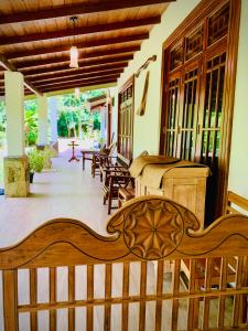 a porch with a wooden bench and tables at Asoria Luxe Resort in Kegalle