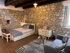 a bedroom with a bed and a stone wall at Old Town Apartment in Krk