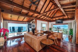a living room with wooden ceilings and a table and chairs at Luxury 4 pool Seaview 6 bedroom Villa on Surin Hill in Surin Beach