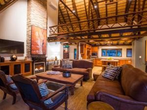 a living room with leather furniture and a fireplace at Hluhluwe Lodge by ANEW in Hluhluwe