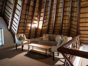 a living room with a couch and a table at Hluhluwe Lodge by ANEW in Hluhluwe +10 photos