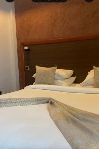a bedroom with two beds with white sheets and pillows at Kika resort hotel in Arusha