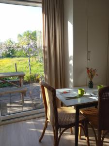 a dining room with a table and chairs and a window at B&B De koekoeksklok in IJsselmuiden