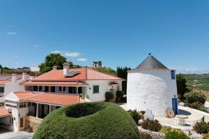 a large white house with a clock tower at Moinhos Da Guimaroa in Cadafais