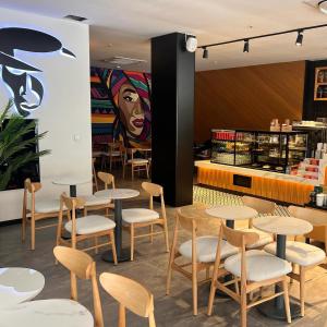 a restaurant with tables and chairs in front of a counter at TELMESSOS CİTY HOTEL- Adults Only in Fethiye