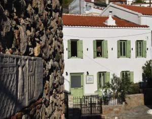 a person looking out the window of a white house at Pelagio Residence in Samothraki
