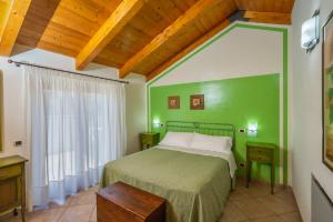 a green bedroom with a bed and a window at Agriturismo Parmenide in Castelnuovo Cilento +49 photos