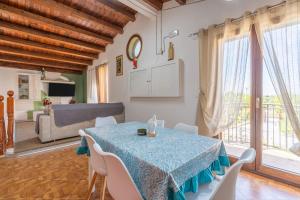 a dining room with a table and a living room at Jungle Holiday Apartment in Avola
