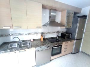 a small kitchen with a sink and a refrigerator at Apartamento Playa Foz in Foz