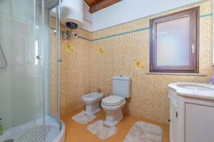 a bathroom with a toilet and a sink and a shower at Jungle Holiday Apartment in Avola +18 photos