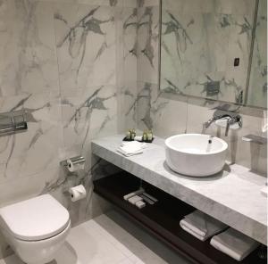 a bathroom with a sink and a toilet and a mirror at Hotel Vasudha Inn-Near International Airport Delhi in New Delhi