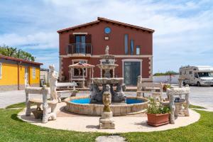 a house with a fountain in front of a house at Jungle Holiday Apartment in Avola