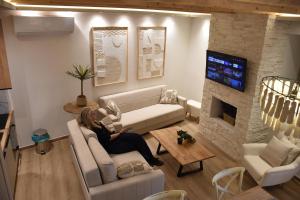 a woman sitting on a couch in a living room at Pelagio Residence in Samothraki