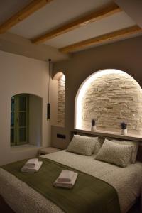 a bedroom with a large bed with a stone wall at Pelagio Residence in Samothraki