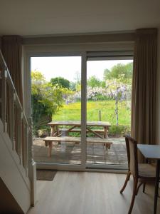 a sliding glass door with a picnic table outside at B&B De koekoeksklok in IJsselmuiden