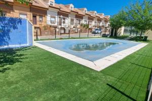 a swimming pool in a yard in front of a building at Villa Rural Las Lomas in Jaén
