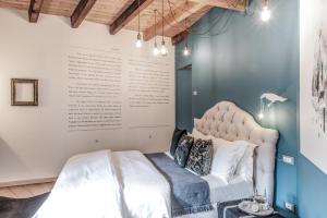 a bedroom with a white bed and a blue wall at Locanda Al Castelletto in Tremosine Sul Garda