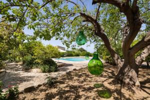 a tree with green glass vases hanging from it at Terre e Torri Country Resort in Lascari