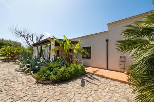 a house with flowers and plants in front of it at Terre e Torri Country Resort in Lascari