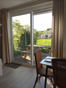 a dining room with a sliding glass door with a table at B&B De koekoeksklok in IJsselmuiden