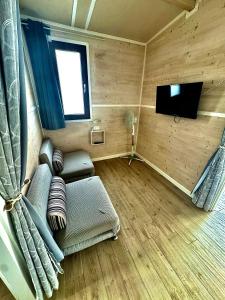 a small room with a couch and a tv in it at Monja Camping Village in Brenzone sul Garda