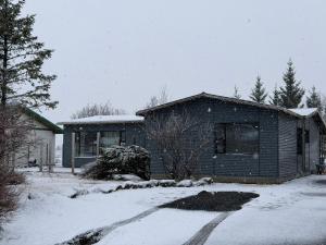 a house with snow on the ground in front of it at Hugleikshus in Hvolsvöllur