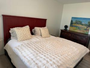 a bed with white sheets and pillows in a bedroom at Hugleikshus in Hvolsvöllur