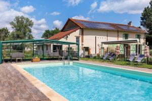 a swimming pool in front of a house at Les Malvaux - Chambres d'hôtes in Huriel