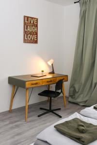 a desk with a lamp and a chair next to a bed at Stilvolles Apartment im Bochumer Stadtkern in Bochum