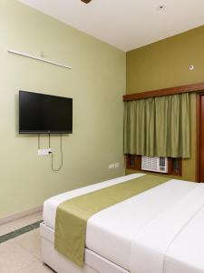 a bedroom with a bed and a flat screen tv at Royal Inn in Lucknow