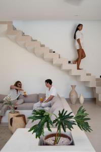 a group of people sitting on a couch under a staircase at Tiga Villas in Kuta Lombok