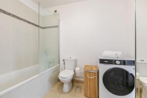 a bathroom with a toilet and a washing machine at Le Cocon d'Achères in Achères