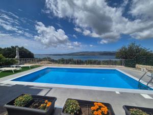 a swimming pool with a view of the water at Apartments Marina House in Fársa