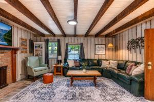 a living room with a green leather couch and a table at Hickory Haven Cozy Lakefront Escape & Dock in Cadiz