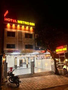 a motorcycle parked in front of a hotel at night at Hotel metro inn in Bhopal