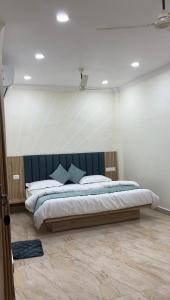 a bedroom with a large bed with a blue headboard at Hotel metro inn in Bhopal