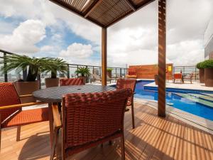 a patio with a table and chairs and a swimming pool at Mercure Belem Boulevard in Belém