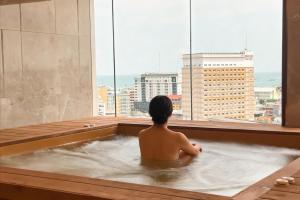 a man sitting in a bath tub in a building at Samsara Hotel Pattaya in Pattaya South