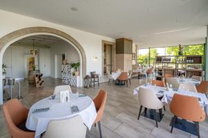 a dining room with white tables and chairs at Auberge de Confignon in Geneva